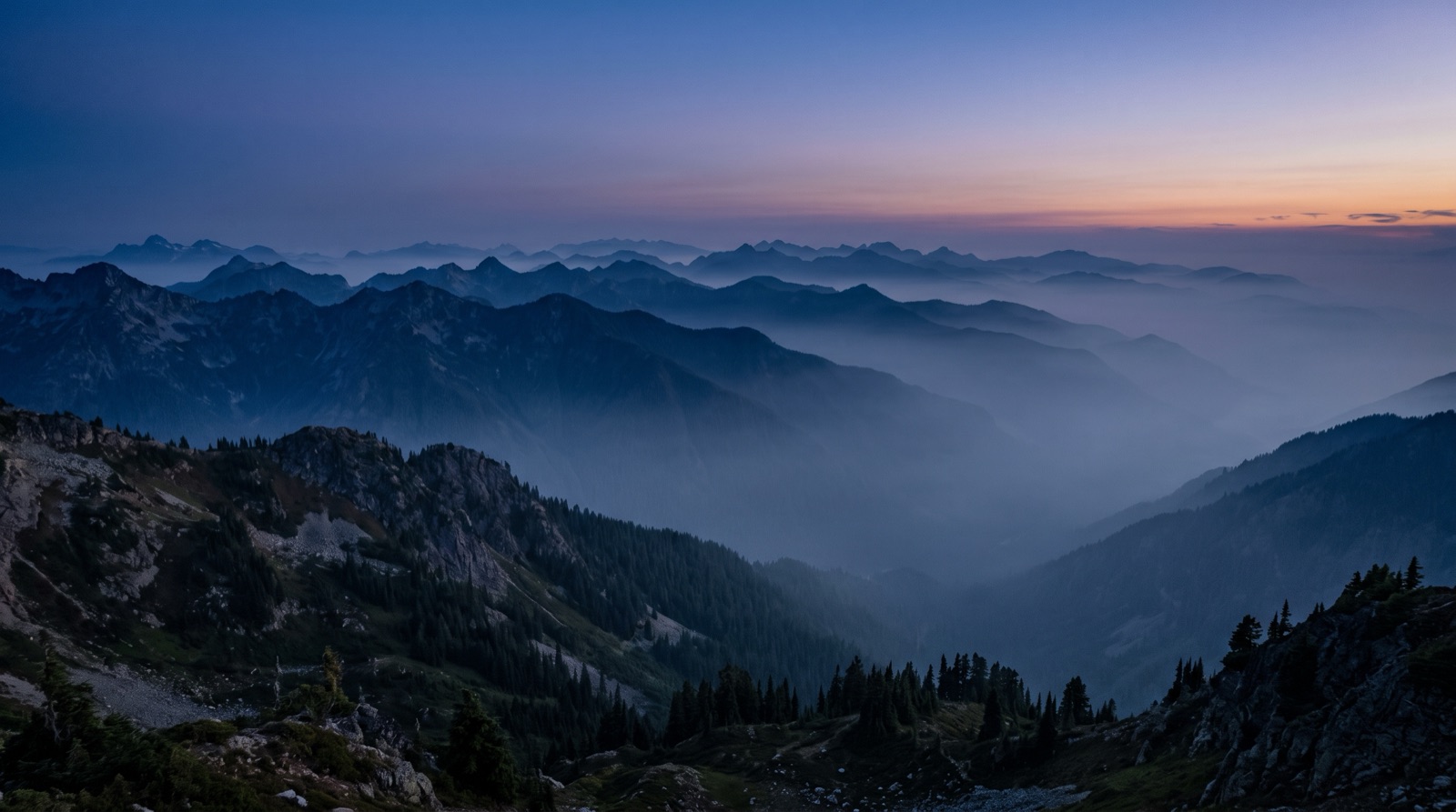 Layered blue mountain ridgelines in fog